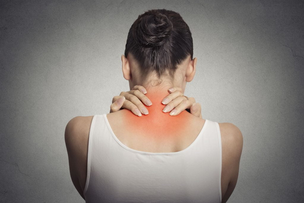 an image of a woman experiencing neck pain which is a symptom of teeth clenching