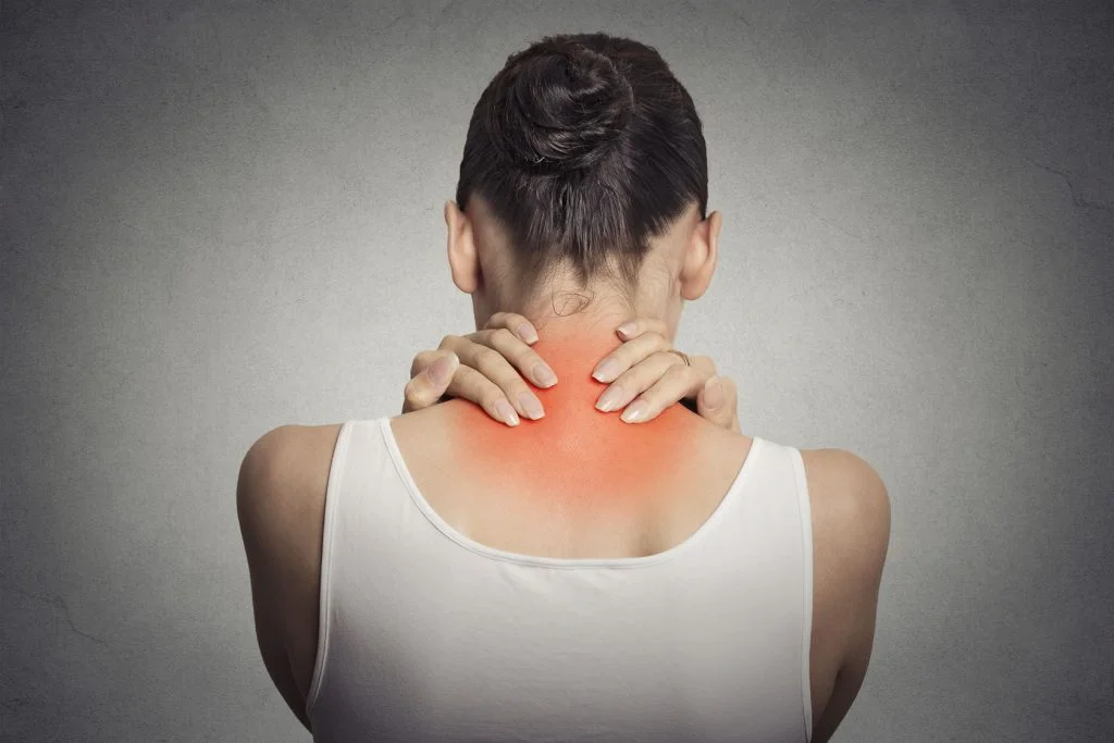 an image of a woman experiencing neck pain which is a symptom of teeth clenching