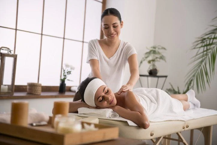 A female massage therapist handing out a massage